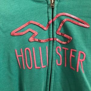 Green-blue hooded jacket with pink accents